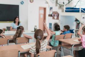 uma professor lê uma livro para elementar escola alunos quem ouço cuidadosamente enquanto sentado dentro uma moderno Sala de aula foto