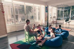 lendo Tempo dentro elementar escola ou Jardim da infância, professor lendo uma livro para crianças dentro elementar escola ou jardim de infância. seletivo foco foto