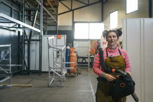 um retrato de uma soldadora segurando um capacete e se preparando para um dia de trabalho na indústria metalúrgica foto
