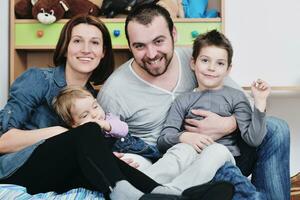 feliz jovem família se diverte em casa foto