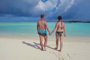 casal jovem feliz nas férias de verão se divertir e relaxar na praia foto