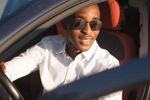 feliz afro-americano dirigindo um carro, no verão