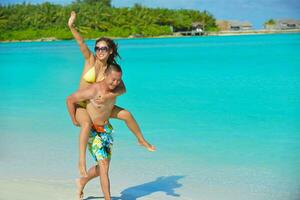 casal jovem feliz curtindo o verão na praia foto