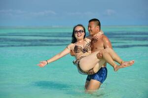 casal jovem feliz curtindo o verão na praia foto