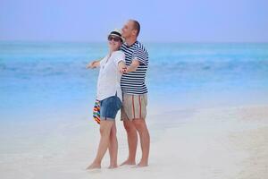 feliz casal jovem se divertir na praia foto