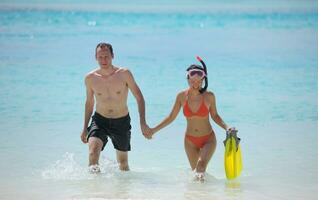 feliz casal jovem se divertir na praia foto