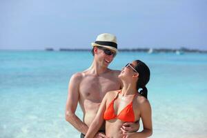 feliz casal jovem se divertir na praia foto