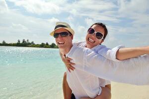 feliz casal jovem se divertir na praia foto