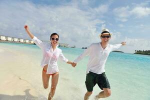 feliz casal jovem se divertir na praia foto