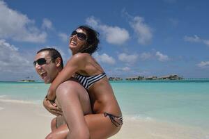 feliz casal jovem se divertir na praia foto