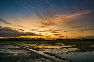 o céu após o pôr do sol sobre os campos de arroz foto