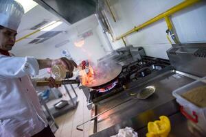 chef fazendo flambe na comida foto