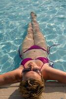 mulher desfrutando feriados dentro a natação piscina foto