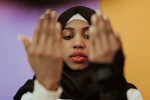 africano muçulmano mulher vestindo hijab e tradicional muçulmano roupas posando dentro frente do amarelo fundo foto