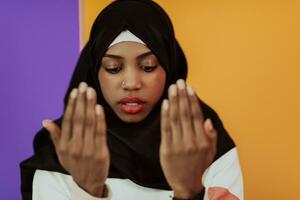 africano muçulmano mulher vestindo hijab e tradicional muçulmano roupas posando dentro frente do amarelo fundo foto