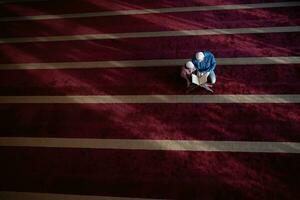 oração muçulmana pai e filho na mesquita orando e lendo o livro de azevinho alcorão juntos conceito de educação islâmica foto