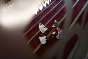 pessoas muçulmanas na mesquita lendo o Alcorão juntos foto