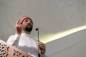 o jovem imã árabe muçulmano faz um discurso na oração da tarde de sexta-feira na mesquita. foto