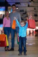 jovem família com sacolas de compras foto