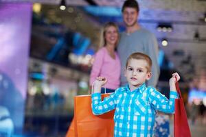 jovem família com sacolas de compras foto