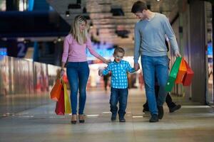 jovem família com sacolas de compras foto