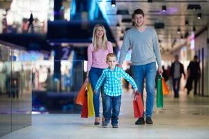 jovem família com sacolas de compras foto