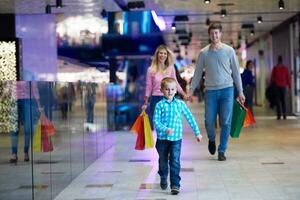 jovem família com sacolas de compras foto