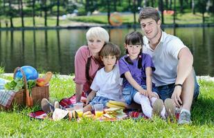 família feliz jogando juntos em um piquenique ao ar livre foto