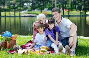 família feliz jogando juntos em um piquenique ao ar livre foto