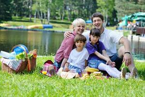 família feliz jogando juntos em um piquenique ao ar livre foto