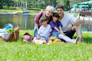 família feliz jogando juntos em um piquenique ao ar livre foto