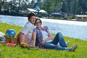 casal jovem feliz fazendo um piquenique ao ar livre foto