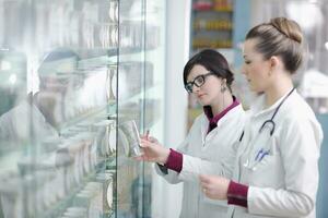 equipe de farmacêutico químico mulher na farmácia farmácia foto