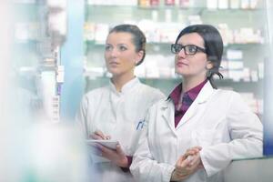 equipe de farmacêutico químico mulher na farmácia farmácia foto