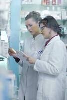 equipe de farmacêutico químico mulher na farmácia farmácia foto