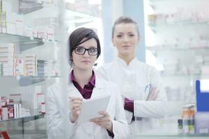 equipe de farmacêutico químico mulher na farmácia farmácia foto