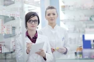 equipe de farmacêutico químico mulher na farmácia farmácia foto