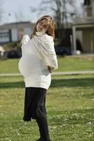 feliz jovem grávida ao ar livre foto