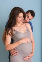 grávida casal isolado sobre azul fundo foto
