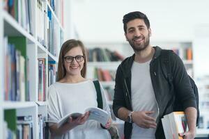 casal de estudantes na biblioteca da escola foto