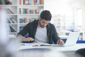 estudante na biblioteca da escola usando laptop para pesquisa foto