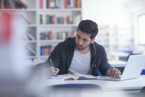 estudante na biblioteca da escola usando laptop para pesquisa foto