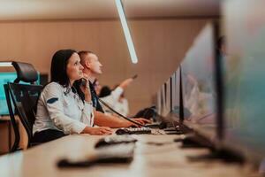 fêmea segurança guarda operador falando em a telefone enquanto trabalhando às posto de trabalho com múltiplo monitores segurança guardas trabalhando em múltiplo monitores foto