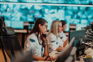 fêmea segurança guarda operador falando em a telefone enquanto trabalhando às posto de trabalho com múltiplo monitores segurança guardas trabalhando em múltiplo monitores foto