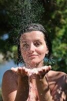 linda mulher lavando e limpando o rosto no chuveiro foto