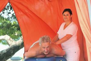homem sênior tem massagem e terapia de spa fora foto