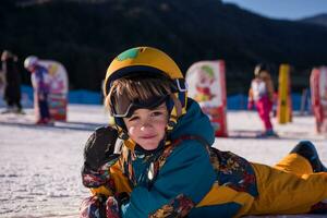 pequeno snowboarder deitado em a neve foto