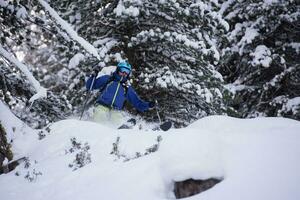 esquiador freeride esquiando na neve em pó profundo foto