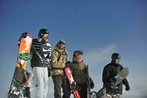 snowboarders grupo relaxante e apreciar Sol foto