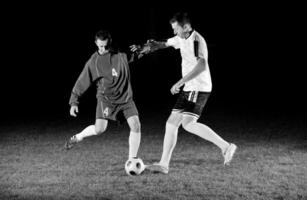 jogadores de futebol em ação para a bola foto